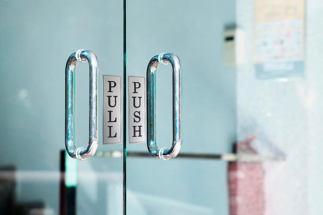 Silver engraved Push and Pull signs on glass door handles